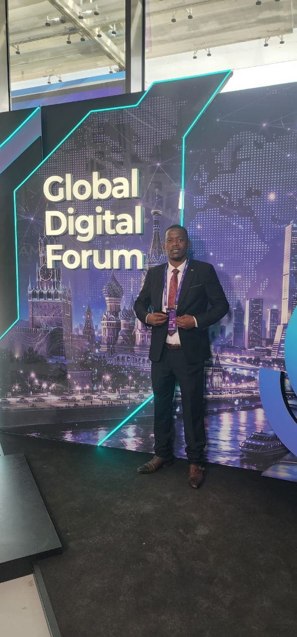 Mussollini Mugumbate in front of the illuminated Global Digital Forum stage backdrop