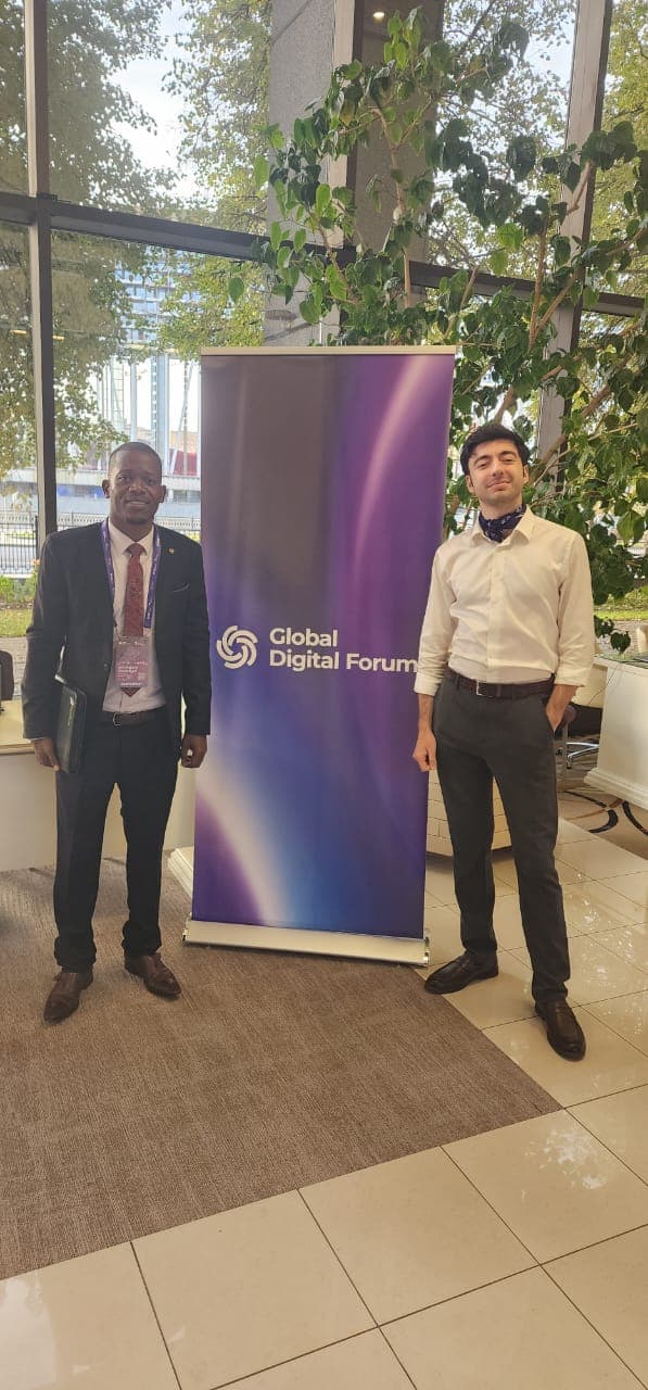 Mussollini Mugumbate with a delegate beside a Global Digital Forum banner